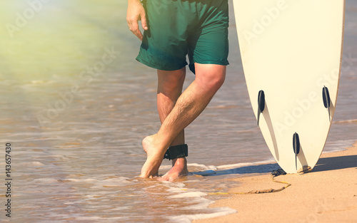Young beautiful surfer men on beach with surf board at day break