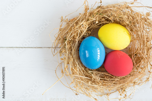 Bright colored dyed eggs on wooden table. Happy Easter eggs card