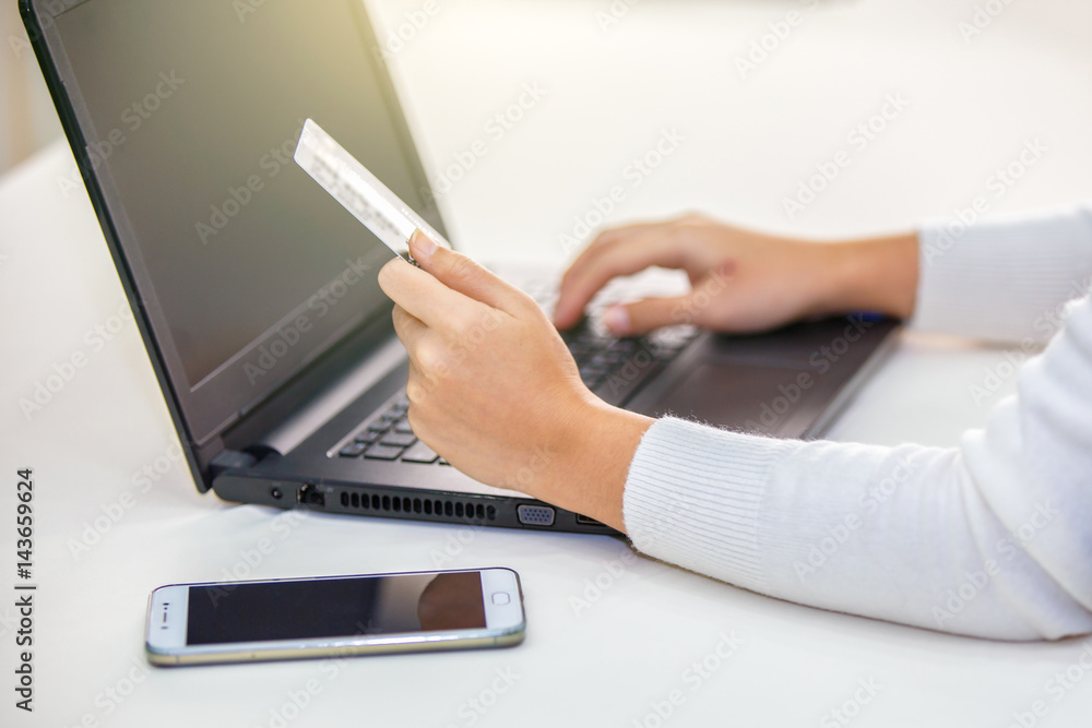Fototapeta premium Hands holding credit card and using laptop. Online shopping