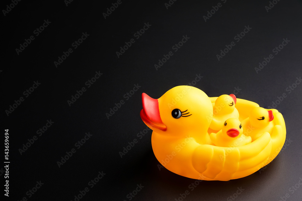 Yellow Mother and baby ducks rubber duck isolated on black background, Cosmetics concept, Makeup concept, Copy space image for your text. Yellow Mother and baby ducks rubber duck isolated on black background, Cosmetics concept, Makeup concept, Copy space image for your text.