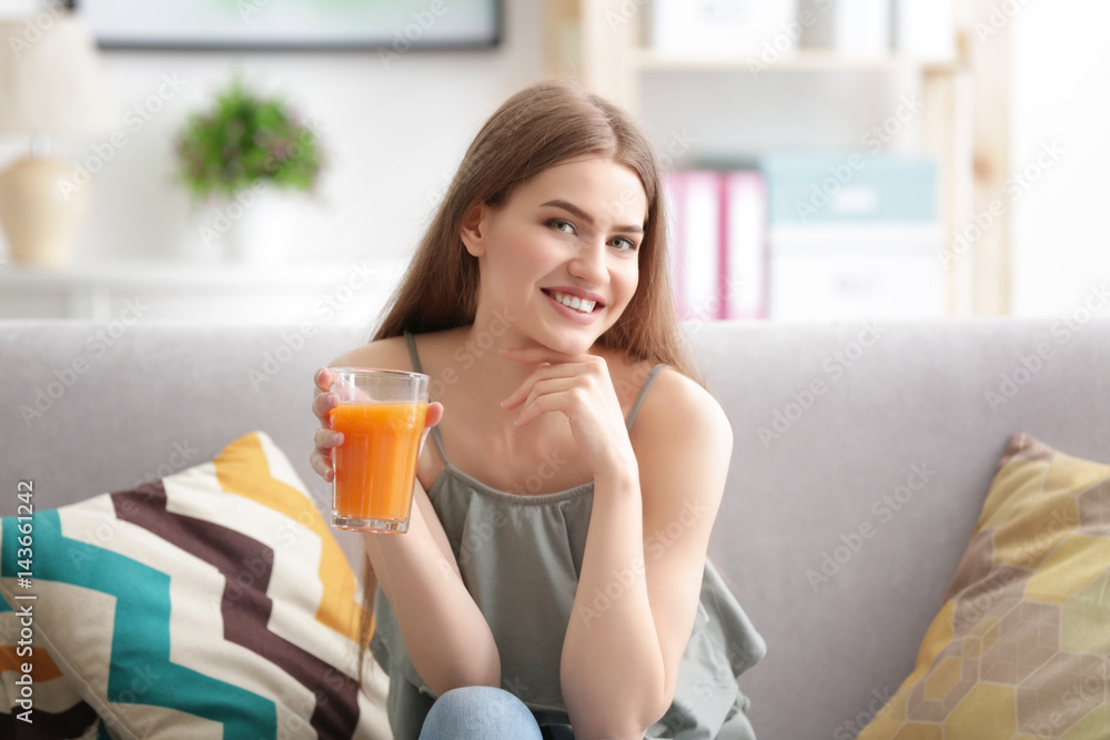 Young woman tasting fresh juice sitting on couch at living room Young woman tasting fresh juice sitting on couch at living room