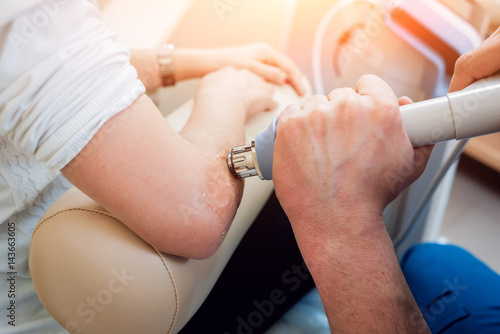 Shock wave therapy. The magnetic field, rehabilitation. Physiotherapist doctor performs surgery on a patient's elbow