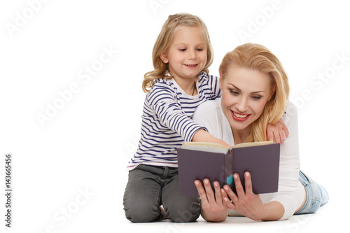 Reading together. Shot of a mother and daughter reading a book together at the studio on white background.
