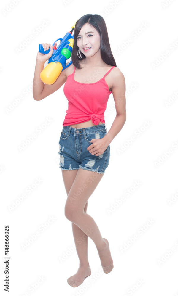 Thailand New year concept. Focus on toy gun. Young happy beauty Asian woman holding plastic water gun at Songkran festival, Thailand. Isolated on white background. Thailand New year concept. Focus on toy gun. Young happy beauty Asian woman holding plastic water gun at Songkran festival, Thailand. Isolated on white background.