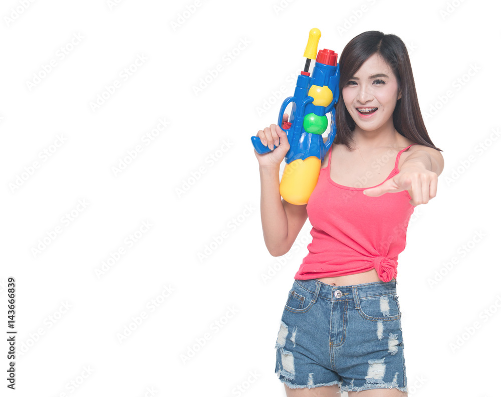 Thailand New year concept. Focus on toy gun. Young happy beauty Asian woman holding plastic water gun at Songkran festival, Thailand. Isolated on white background. Thailand New year concept. Focus on toy gun. Young happy beauty Asian woman holding plastic water gun at Songkran festival, Thailand. Isolated on white background.