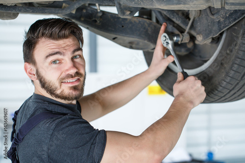 Fotografie Professional car mechanic working on wheels