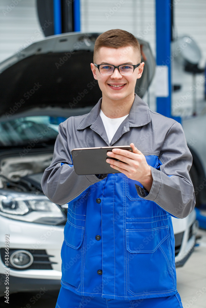 Young mechanic using digital tablet Young mechanic using digital tablet