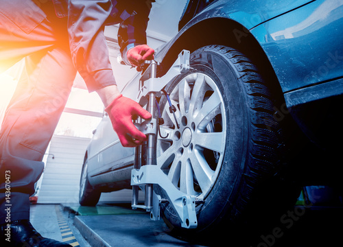 Φωτογραφία Car mechanic installing sensor during suspension adjustment.