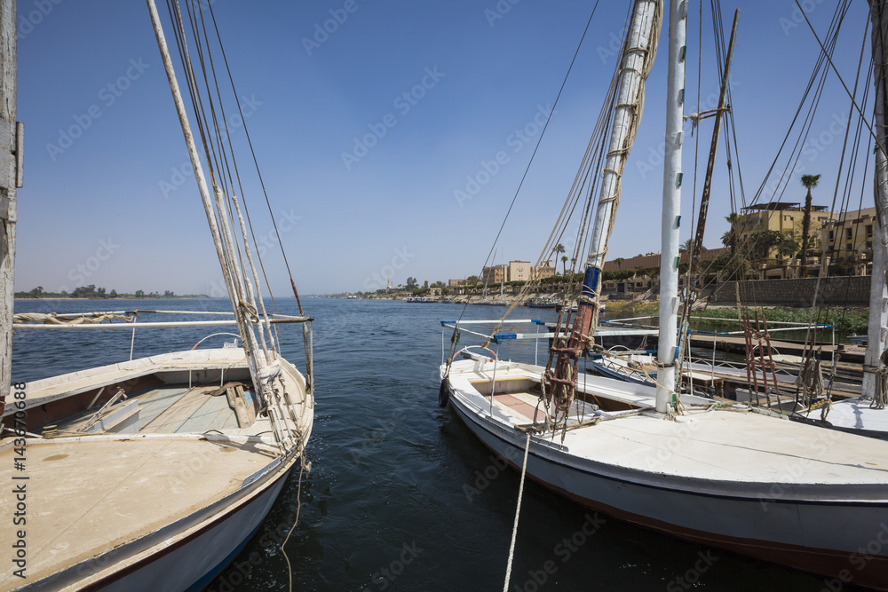 Wooden boats felucca at the Nile River in Aswan, Egypt, North Africa Wooden boats felucca at the Nile River in Aswan, Egypt, North Africa