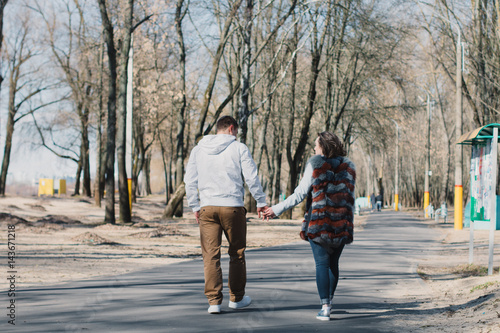 Happy couple in love hugging and sharing emotions, holding hands walking in the park