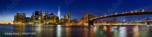 Panoramic view of Lower Manhattan Financial District skyscrapers at twilight with the Brooklyn Bridge. New York City