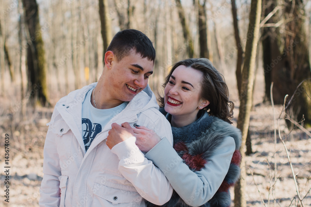 Happy couple in love hugging and sharing emotions, holding hands walking in the park Happy couple in love hugging and sharing emotions, holding hands walking in the park