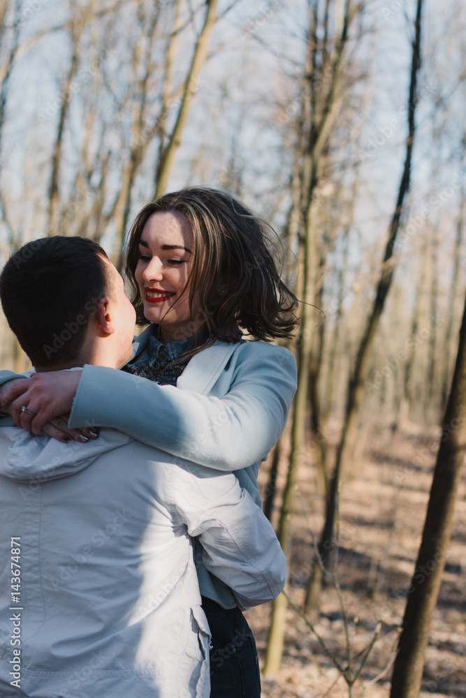 Happy couple in love hugging and sharing emotions, holding hands walking in the park Happy couple in love hugging and sharing emotions, holding hands walking in the park