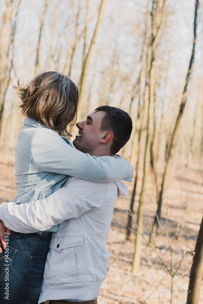 Happy couple in love hugging and sharing emotions, holding hands walking in the park Happy couple in love hugging and sharing emotions, holding hands walking in the park