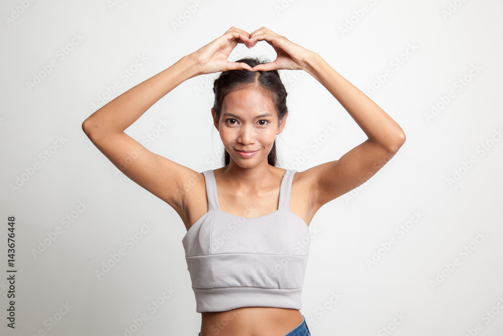 Young Asian woman gesturing heart hand sign. Young Asian woman gesturing heart hand sign.