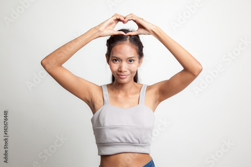 Young Asian woman gesturing  heart hand sign. © halfbottle