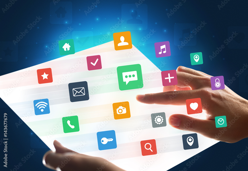 Hands touching a glass-like tablet with colorful icons Hands touching a glass-like tablet with colorful icons