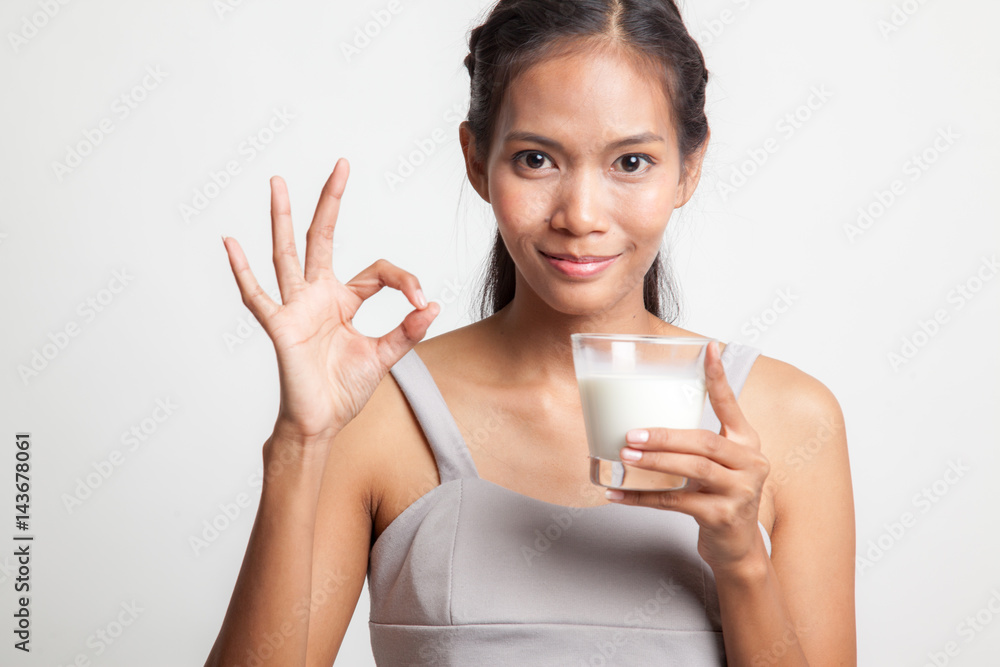 Healthy Asian woman drinking a glass of milk show OK sign. Healthy Asian woman drinking a glass of milk show OK sign.