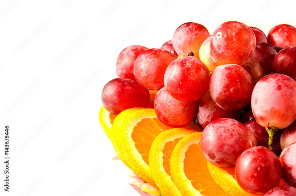 plate with oranges and grapes on white background