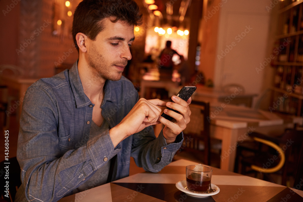 Charming millenial texting in a restaurant Charming millenial texting in a restaurant
