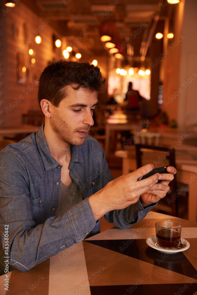 Concentrating millenial texting in a restaurant Concentrating millenial texting in a restaurant