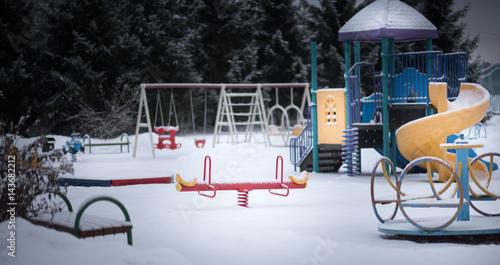 Photography Children's Playground with swings and a slide in the snow