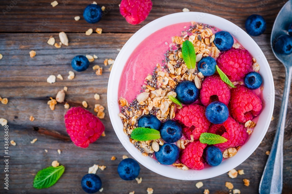 Breakfast smoothie bowl with granola, fresh raspberry, blueberry, chia seeds and mint Breakfast smoothie bowl with granola, fresh raspberry, blueberry, chia seeds and mint