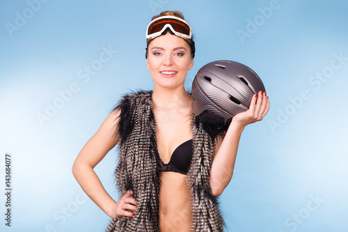 Woman wearing bra and holding ski helmet © Voyagerix