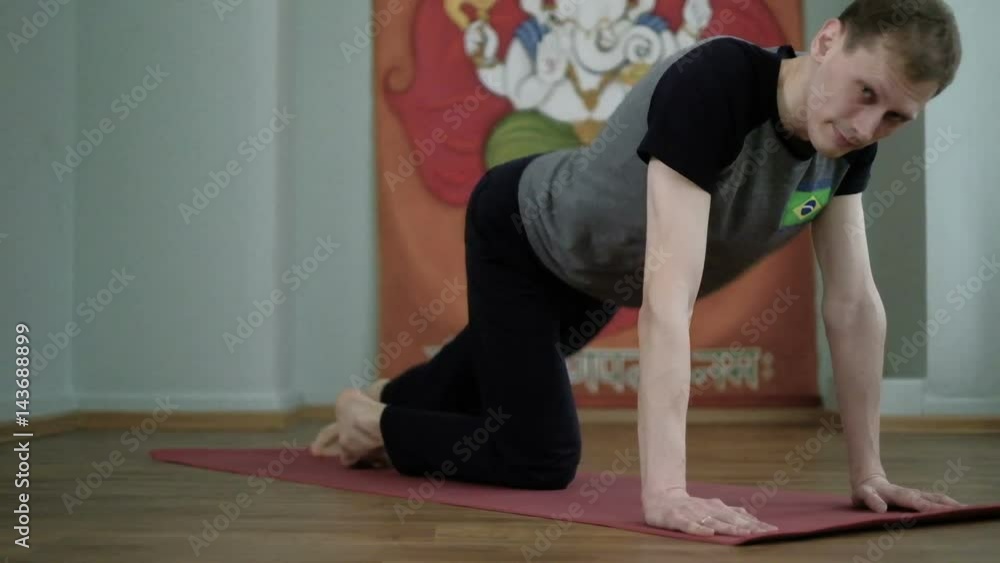 A man yoga makes a healthy stretching in the studio A man yoga makes a healthy stretching in the studio