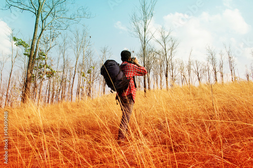 Traveler with backpack taking photo on the mountain