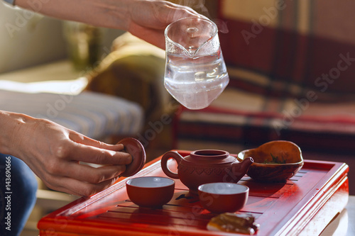 The tea ceremony. The woman pours hot water into the teapot