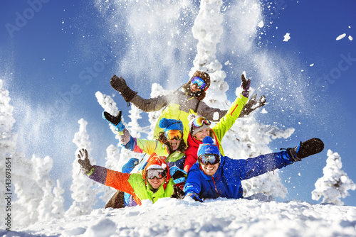 Group of five happy snowboarders and skiers