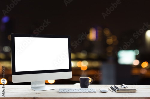 desktop computer on work table and city night background