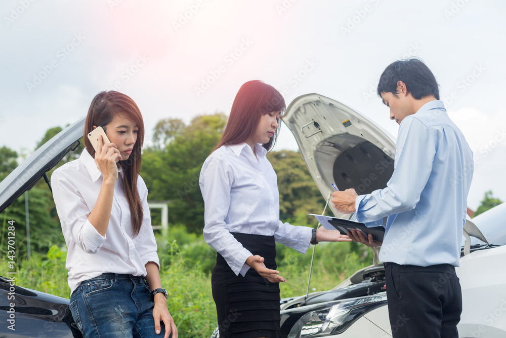 Car collision. Asian driver man and woman examining damaged automobile cars after crash accident in city Car collision. Asian driver man and woman examining damaged automobile cars after crash accident in city