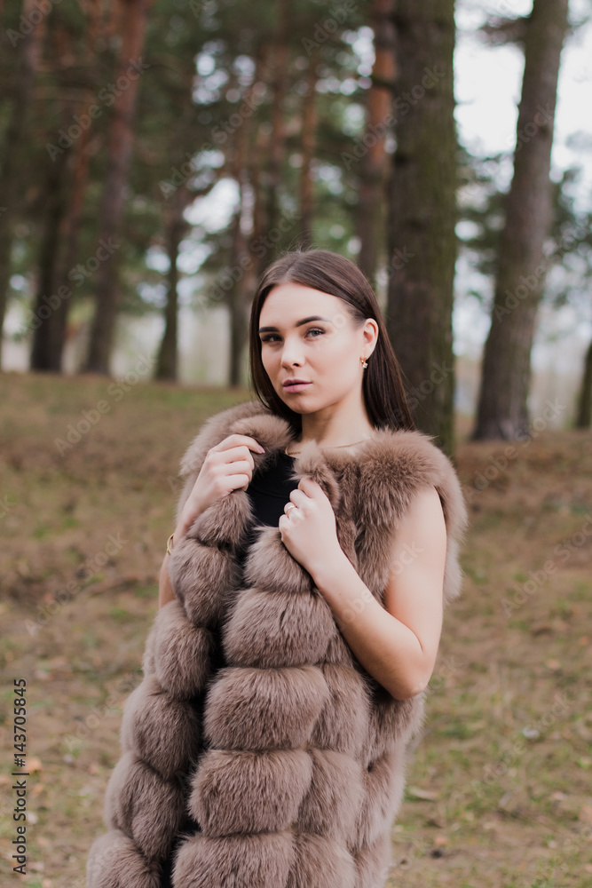 Portrait of a very beautiful girl in a forest dressed in fur Portrait of a very beautiful girl in a forest dressed in fur