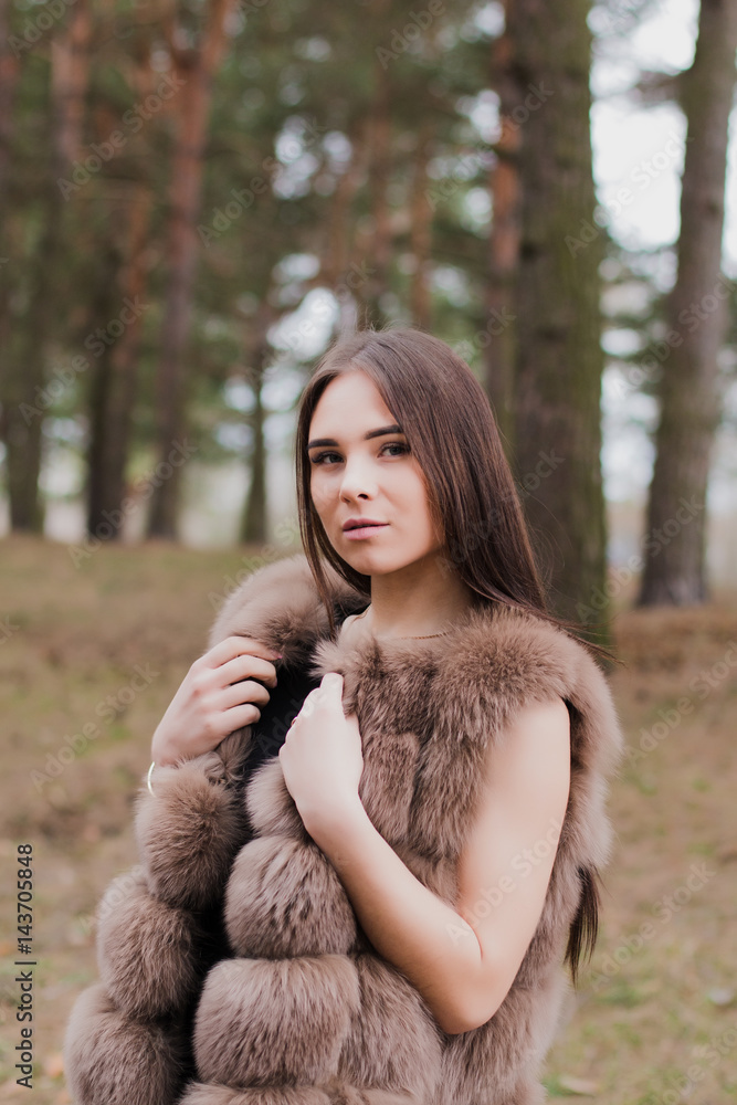 Portrait of a very beautiful girl in a forest dressed in fur Portrait of a very beautiful girl in a forest dressed in fur