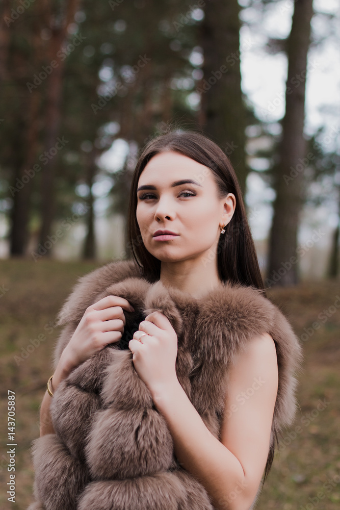 Portrait of a very beautiful girl in a forest dressed in fur Portrait of a very beautiful girl in a forest dressed in fur
