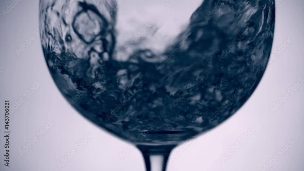 Slo-motion water poured into glass at white background Slo-motion water poured into glass at white background