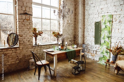 Loft interior with brick wall, table and chairs