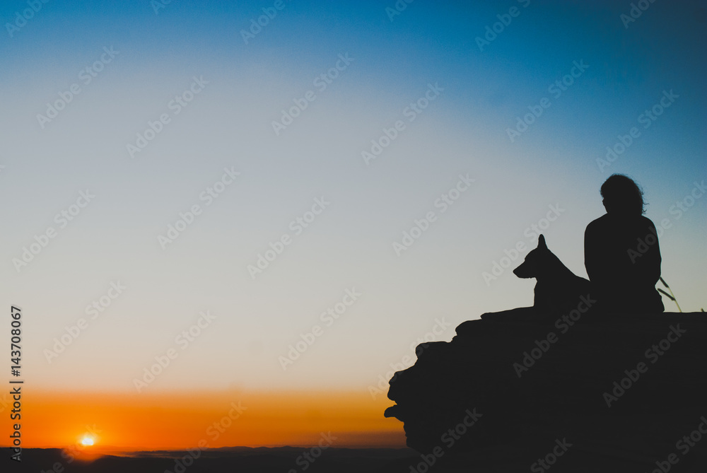 Girl and dog silhouettes at sunrise in Brazil