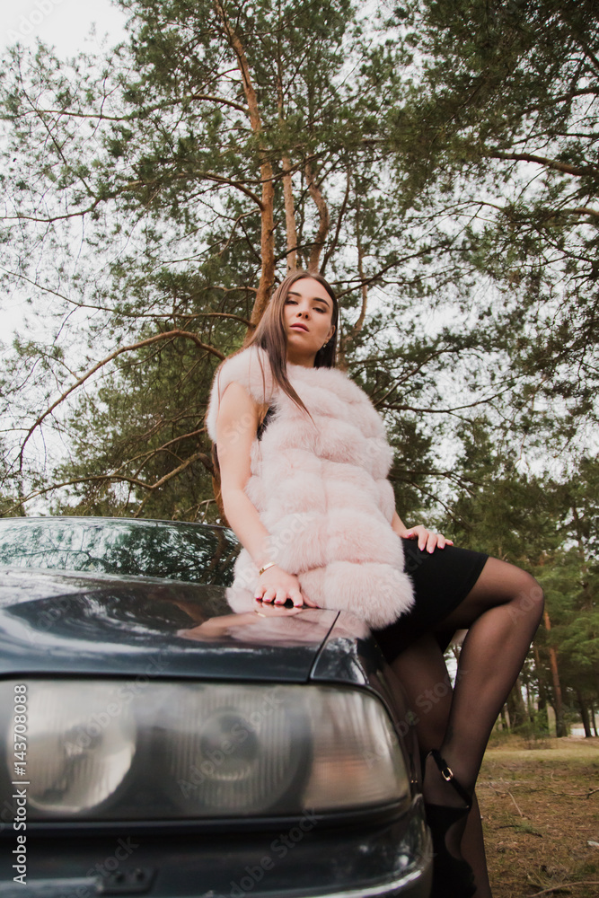 Portrait of a very beautiful girl in a forest dressed in fur in a car Portrait of a very beautiful girl in a forest dressed in fur in a car