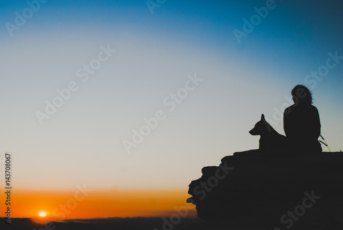 Girl and dog silhouettes at sunrise in Brazil