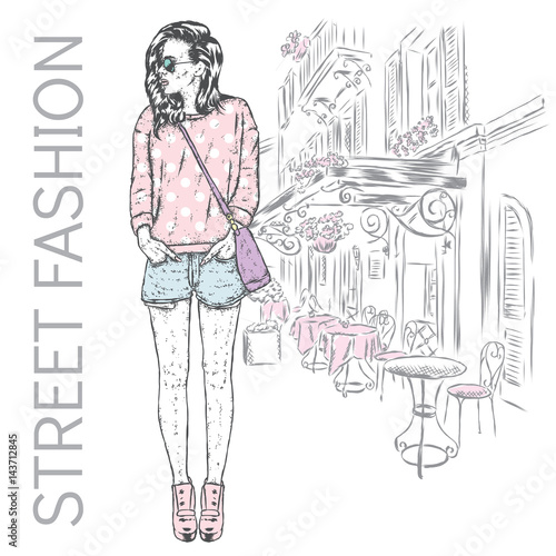 Beautiful girl in shorts  hoodies and boots in heels. Vector illustration for a postcard or a poster. Slender model with long legs against the background of a city street.