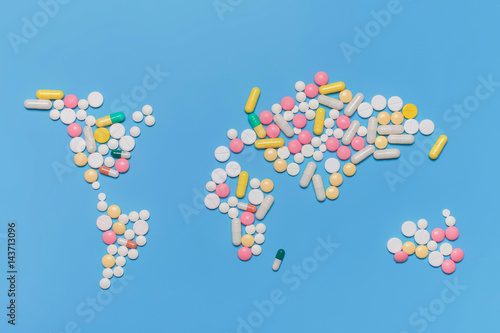 Pills in world map shape. Blue background