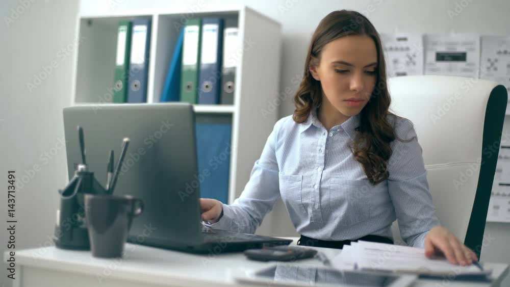 Beautiful businesswoman working on her laptop while sitting at office Beautiful businesswoman working on her laptop while sitting at office