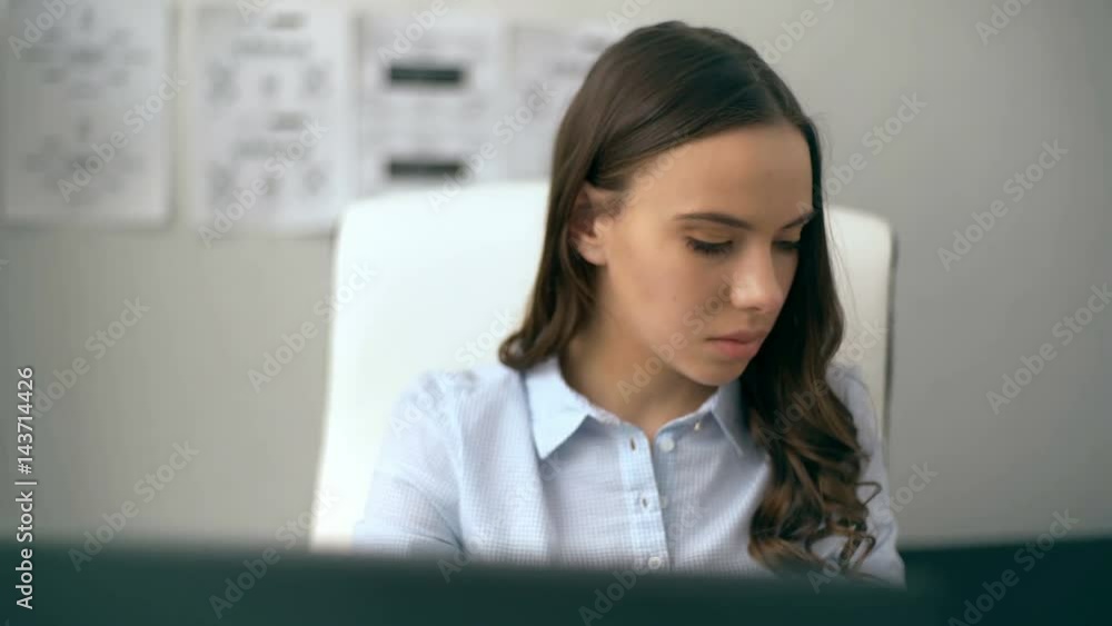 Beautiful businesswoman working on her laptop while sitting at office Beautiful businesswoman working on her laptop while sitting at office