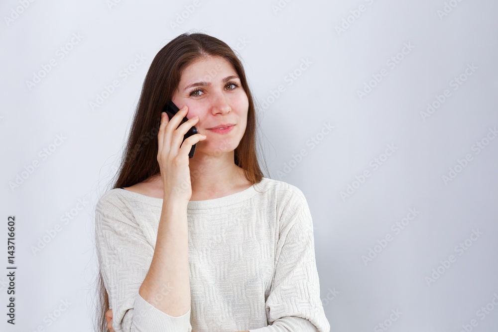 Portrait of young woman talking on the phone. Human reaction, expression. Grey background. Portrait of young woman talking on the phone. Human reaction, expression. Grey background.