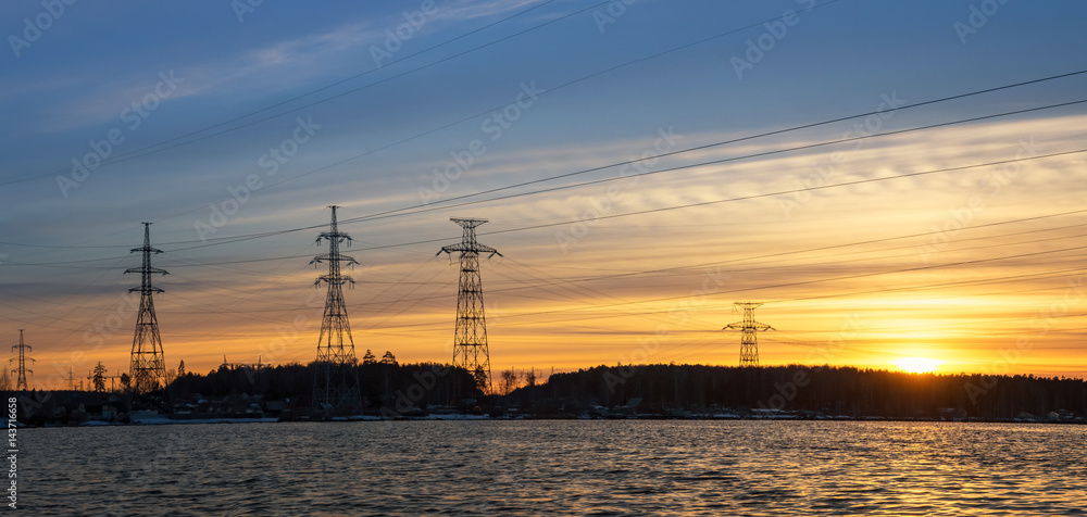 Fototapeta premium панорама линии электропередач на берегу водохранилища на закате дня, Энергия