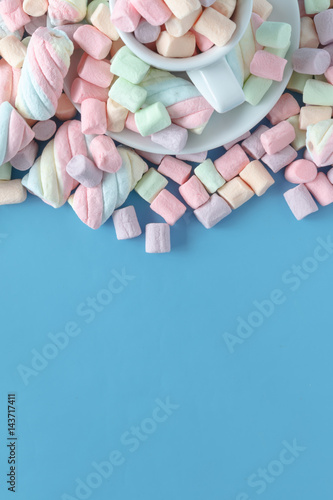 Small round multicolor marshmallows on a blue backgrouns. © Andrey Cherkasov