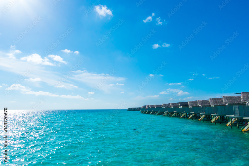 Water villas over calm sea  in tropical Maldives island .